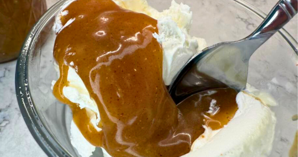 Homemade Apple Cider Salted Caramel Recipe over ice cream with a spoon.